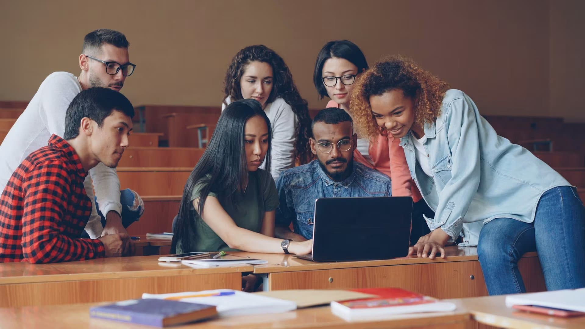 Groupe de jeunes adultes en formation autour d'un ordinateur portable